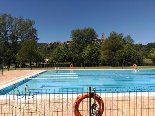 ein Pool mit einem Volleyballplatz in der Unterkunft Apartamentos Casa Rivera in Aínsa