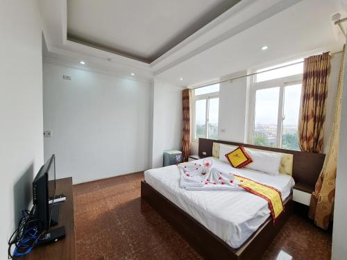a bedroom with a bed with a television and a window at Khách sạn Crown - Gần đại học Nông Lâm TN in Thái Nguyên