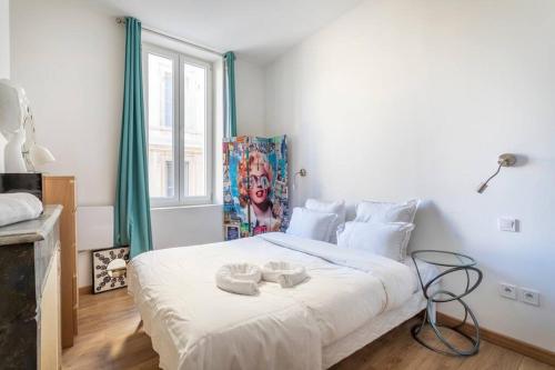 une chambre avec un grand lit blanc avec deux serviettes dessus dans l'établissement 7FOUR Appartement avec vu Major, à Marseille