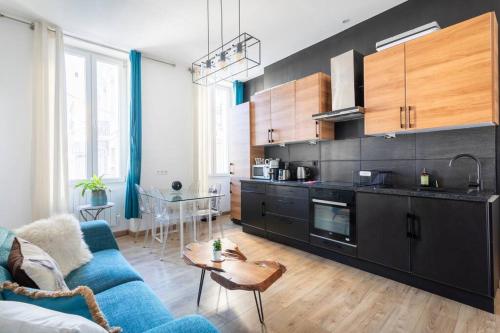 un salon avec un canapé bleu et une cuisine dans l'établissement 7FOUR Appartement avec vu Major, à Marseille