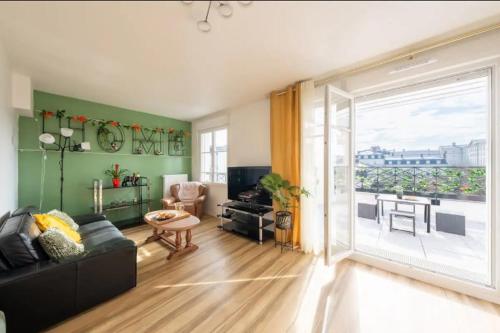 un salon avec un canapé et une grande fenêtre dans l'établissement Disney at home 3 bed rooms- Confort 90m2 - best location, à Serris