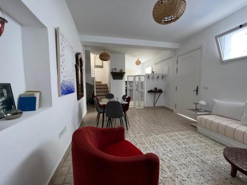 a living room with a red chair and a table at Stella Maris, Asilah medina in Asilah