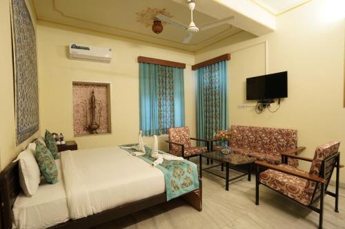 um quarto com uma cama, uma mesa e cadeiras em Hotel Radoli House - A Heritage Hotel em Jaipur