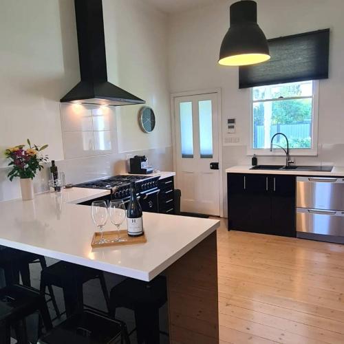 a kitchen with a table with wine glasses on it at The Cottage at Seppeltsfield, Barossa Valley in Seppeltsfield