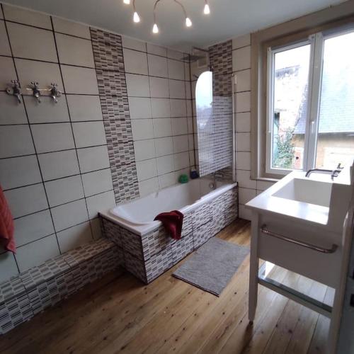 une salle de bain avec une baignoire et un lavabo dans l'établissement Maison de ville rénovée au cœur du Cotentin., à Périers
