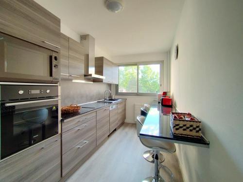 cocina con encimera y fogones horno superior en Chic and comfortable apart near Paris, en Colombes