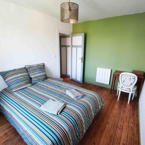- une chambre avec un lit, une chaise et une table dans l'établissement Maison de ville rénovée au cœur du Cotentin., à Périers
