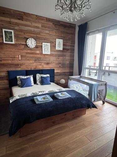 um quarto com uma cama grande e uma parede de madeira em Lake Park Apartament with free parking Airport Netflix em Varsóvia