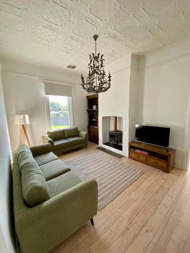 a living room with a couch and a television at The Cottage at Seppeltsfield, Barossa Valley in Seppeltsfield