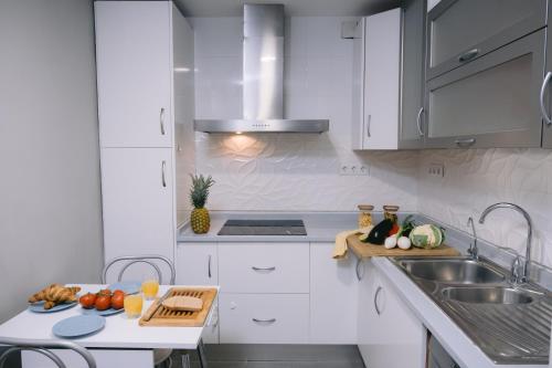 a kitchen with white cabinets and a sink at Piso compartido Delyrent, Reja in Jaén