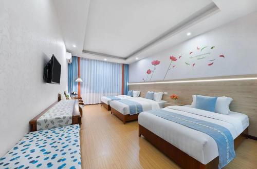 a hotel room with three beds and flowers on the wall at Emeishan Hongzhao Hotel in Emeishan City