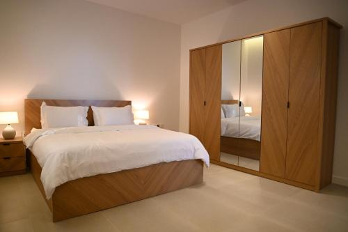 - une chambre avec un grand lit et un grand miroir dans l'établissement 2 Bedroom Apartment in Jeddah, à Djeddah