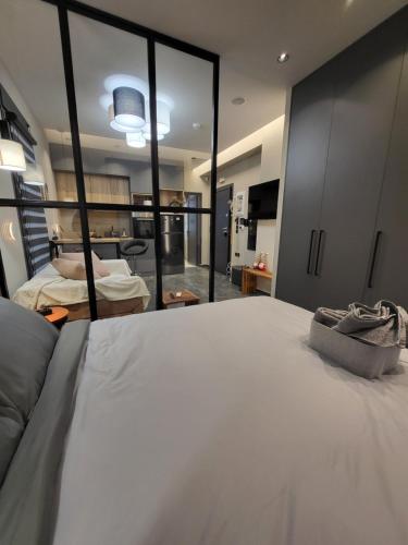 um quarto com uma cama branca e uma grande janela em Modern studio in Veria center, near Elia square em Veria