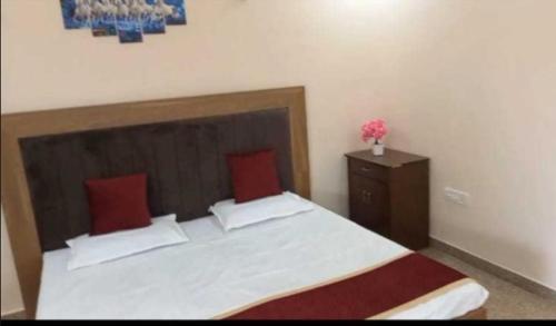 Un dormitorio con una cama grande con almohadas rojas. en Prayas homestay, en Agra