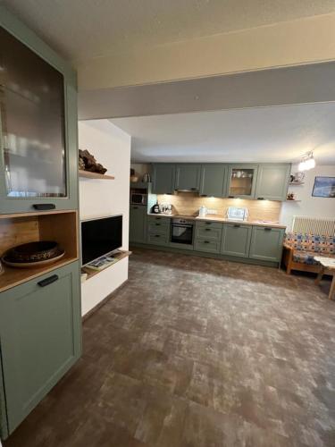 a large kitchen with green cabinets and a table at Ferienhäuser Thalbach in Heiligenblut