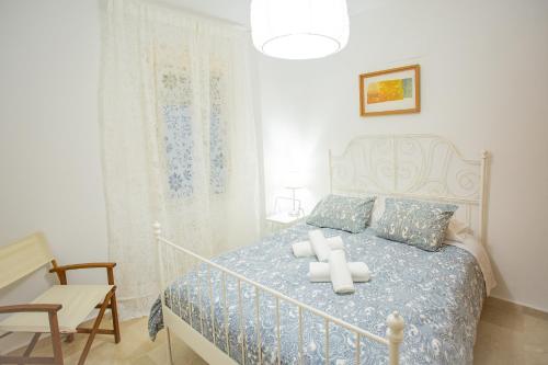 um quarto com uma cama e uma cadeira em WISH SUITE CALATRAVA DE SEVILLA em Sevilha