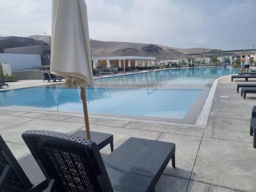 una sombrilla sentada en una silla junto a una piscina en Casa de Playa en Puerto Viejo, en San Antonio