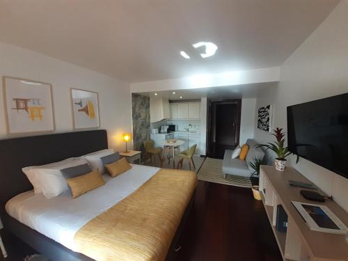 a bedroom with a large bed and a living room at Health Village Apartments in Cascais