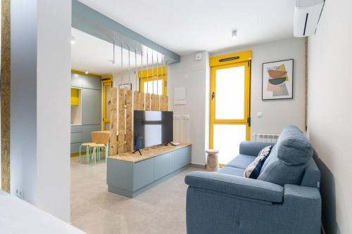 un soggiorno con divano blu e tavolo di Estudio moderno y acogedor en Madrid Rio nº4 a Madrid