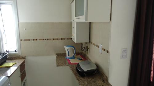 a kitchen with a sink and a dog bowl on the counter at Departamento Temporario Villa Sol in Cordoba