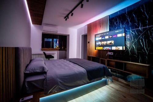 1 dormitorio con 1 cama y TV de pantalla plana en Elite Studio Apartament, en Câmpulung Moldovenesc