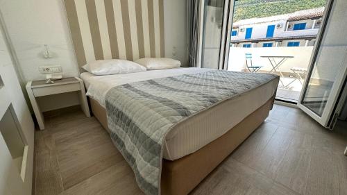 a bedroom with a bed and a large window at Hotel Aleksandar in Budva