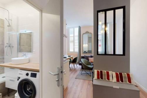une salle de bain avec un lavabo et une machine à laver dans l'établissement 5PAV Charmant T2 centre de Marseille, à Marseille