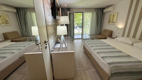 a bedroom with two beds and a living room at Hotel Aleksandar in Budva
