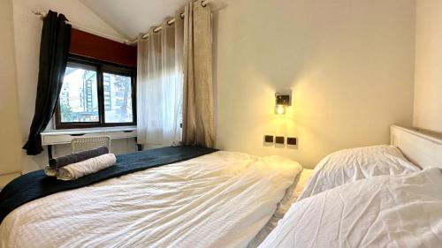 a bedroom with two beds and a window at Salamandra Guest House מקלט פרטי in Nahariyya