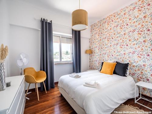 um quarto com uma cama, uma secretária e uma janela em Akicity Ameixoeira Light em Lisboa