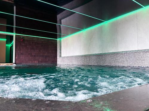 una piscina de agua con luces verdes en un edificio en Hellidon Lakes Hotel, en Daventry