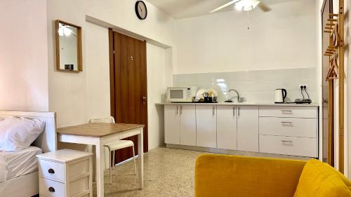 a small kitchen with a table and a sink at Salamandra Guest House מקלט פרטי in Nahariyya