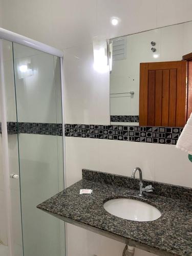 a bathroom with a sink and a shower at Oscar Palace Hotel - Centro de Tubarão in Tubarão