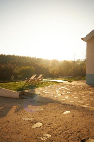 a couple of benches sitting in a park at Quinta do Marmeleiro - Casa Marmeleiro in Santiago do Cacém