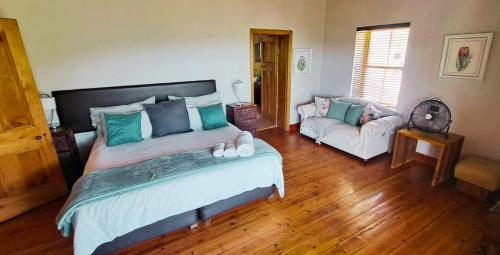 a bedroom with a large bed and a couch at Mountainview Vineyards in Robertson