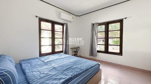 ein Schlafzimmer mit einem Bett und zwei Fenstern in der Unterkunft Happy Home Villa 1 in Nathon Bay