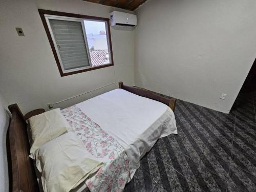 Habitación pequeña con cama y ventana en Casa a 600m praia dos Ingleses en Florianópolis