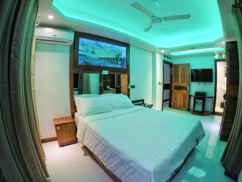 a bedroom with a large bed and a flat screen tv at ZAN Lodge in Male City