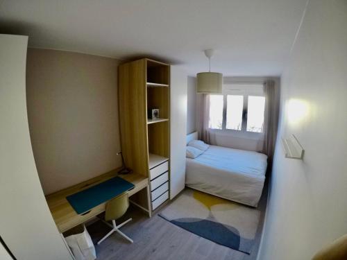 um pequeno quarto com uma cama e uma secretária em Charming & cosy rooms Nantes (chambres chez l'habitant) em Nantes