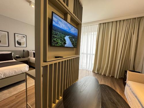 a room with a bed and a television on a wall at Guemes Hotel & Spa in Salta