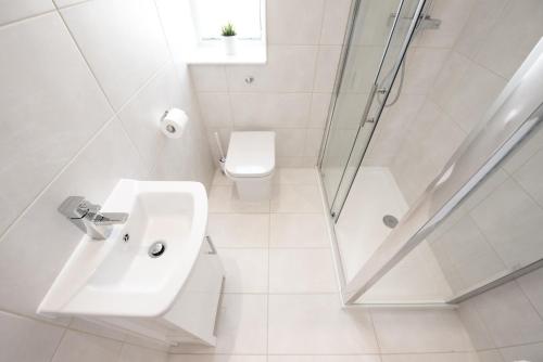a white bathroom with a sink and a shower at Space Apartments - One Bed Seafront Apartment 4 in Harwich