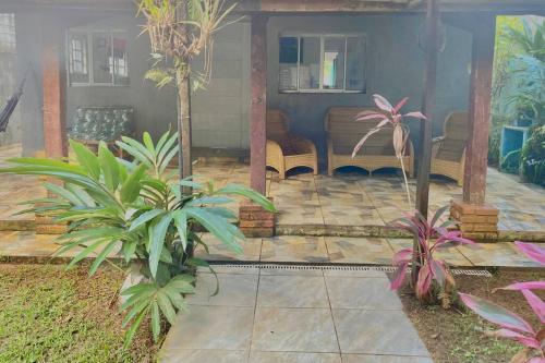 a patio with chairs and plants in front of a house at Casa de Praia com piscina in São Sebastião