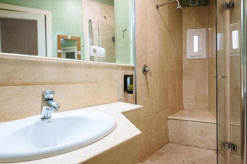 a bathroom with a sink and a shower at The Zentral Suites & Apartments in Seville