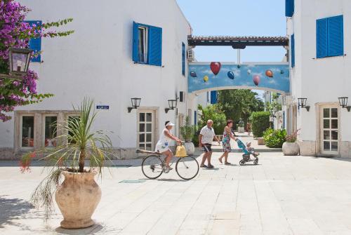 a group of people riding a bike down a street at Hotel Slovenska Plaža in Budva