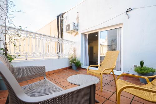 a balcony with two chairs and a table and chairs at The Zentral Suites & Apartments in Seville