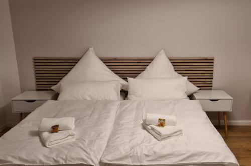 łóżko z białą pościelą i dwoma ręcznikami w obiekcie Stilvoll, Zentral, Einzigartig I Küche I Parkplatz w mieście Paderborn