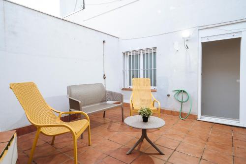 a living room with chairs and a table at The Zentral Suites & Apartments in Seville