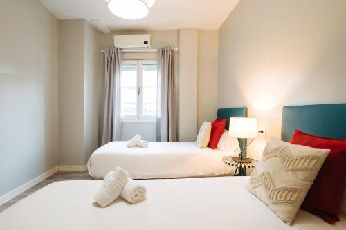 a bedroom with two beds and a window at The Zentral Suites & Apartments in Seville