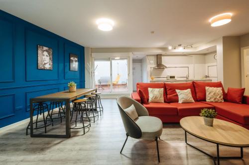 a living room with a red couch and a table at The Zentral Suites & Apartments in Seville