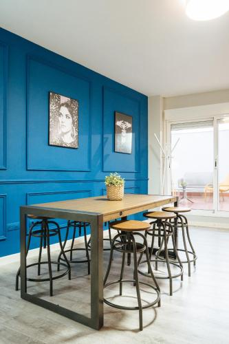 a dining room with blue walls and a wooden table at The Zentral Suites & Apartments in Seville